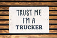 a white sign that says trust me i'm a trucker