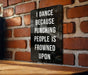 a sign on a brick wall that says i dance because punching people is frowned