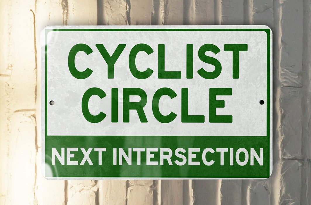 a green and white sign that says cyclist circle next intersection