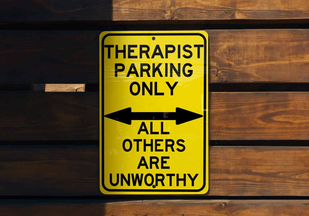 a yellow sign on a wooden wall that says therapst parking only all
