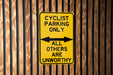 a yellow and black sign on a wooden wall