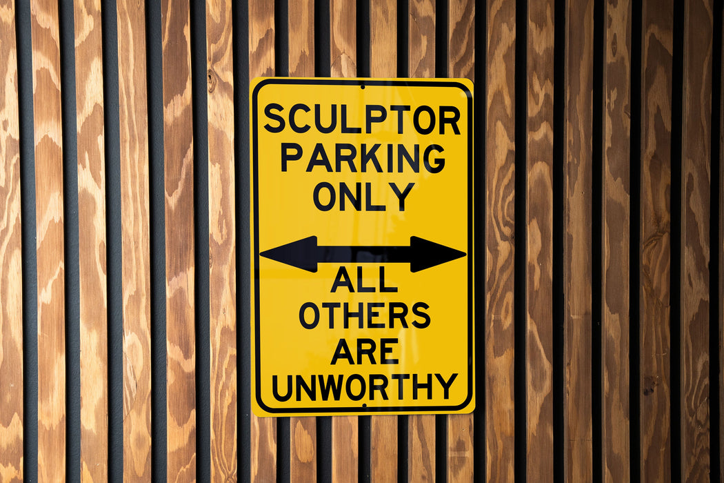 a yellow parking only sign on a wooden wall