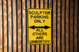 a yellow parking only sign on a wooden wall