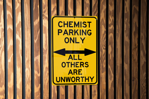 a yellow and black sign on a wooden wall