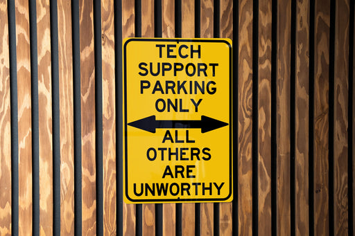 a yellow sign that says tech support parking only all others are unworthyly