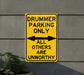 a yellow sign that says drummer parking only all others are unworthyly