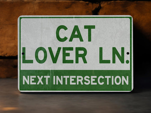 a green and white sign that says cat lover ln next intersection