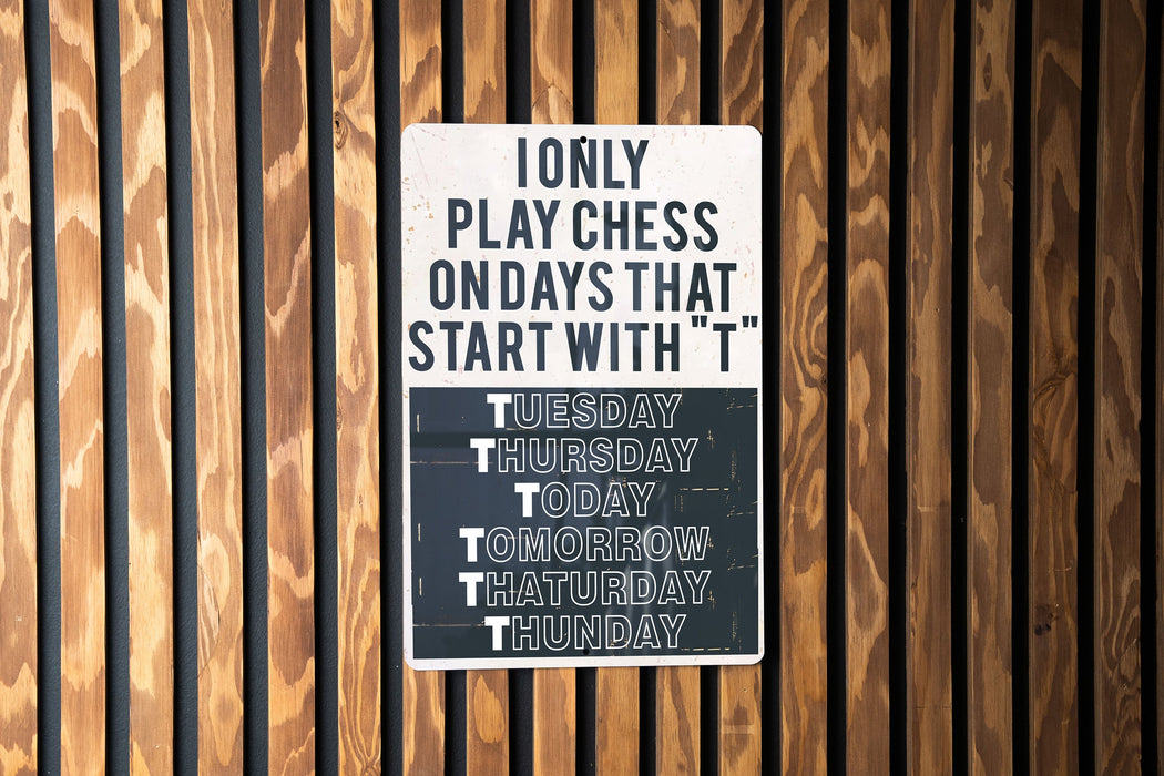 a sign on a wooden wall that says only play chess on days that start with