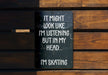 a sign on a wooden bench that says it might look like i'm listening