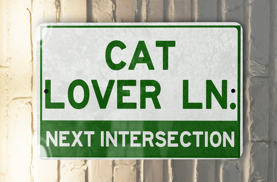 a green and white sign that says cat lover ln next intersection