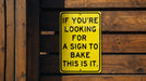 a yellow sign that says if you're looking for a sign to bake