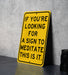 a yellow sign that says if you're looking for a sign to meditate