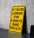 a yellow sign that says if you're looking for a sign to bake