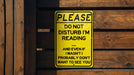 a yellow sign that is on a wooden fence