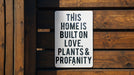 a sign that says this home is built on love, plants and propanety