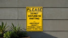 a yellow sign that says please don't disturb i'm knitting and even