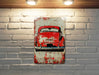 a painting of a red car on a white brick wall