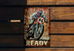 a painting of a motorcycle rider on a rusty sign