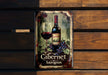 a bottle of cabernet sauvignon on a wooden bench