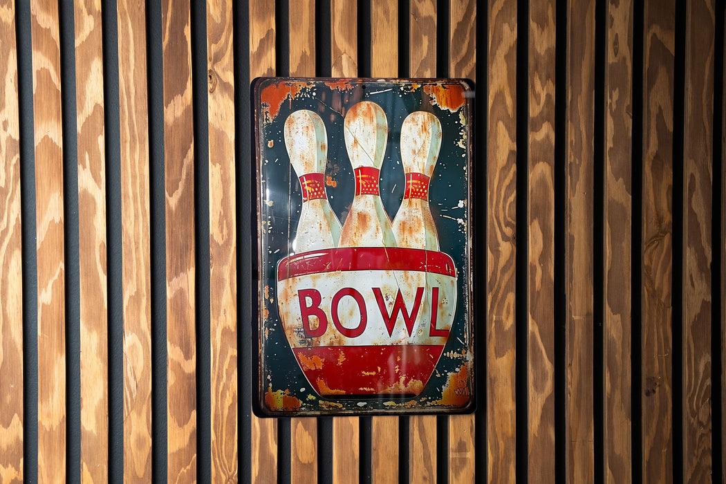 a bowling sign hanging on a wooden wall