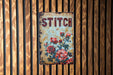 a sign on a wooden wall that says stitch