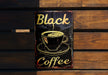 a sign on a wooden wall that says black coffee