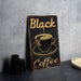 a black coffee sign sitting on top of a table
