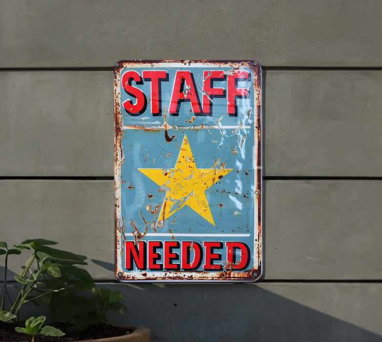 a sign on a wall that says staff needed