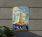 a sail sign hanging on the side of a building