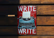 a red and white sign with a typewriter on it