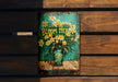 a painting of flowers in a vase on a wooden bench