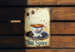 a metal sign with a cup of coffee on it