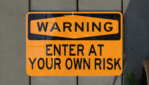 a yellow and black street sign on a wall