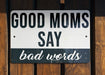 a white and black street sign on a wooden fence