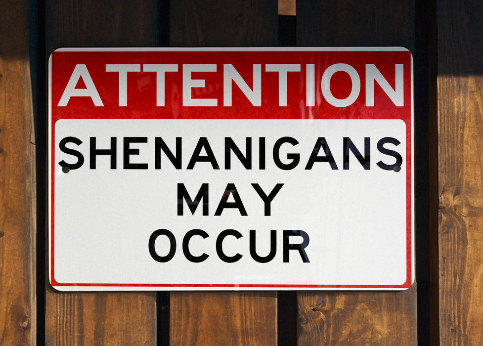 a red and white street sign on a wooden fence