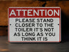 a red and white sign that says attention please stand close to the toilet it '