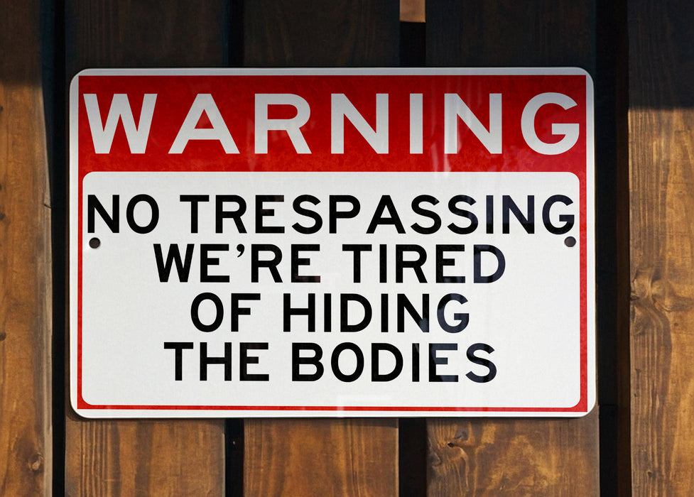 a red and white sign on a wooden fence