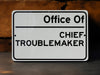 a white sign that says office of chief troublemaker