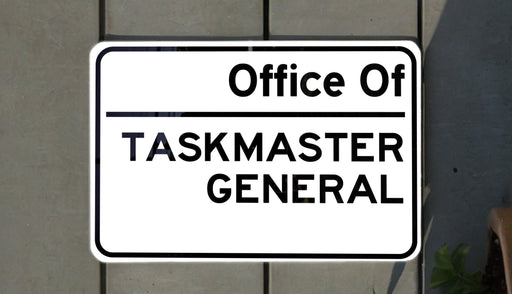 a white and black sign on a brick wall