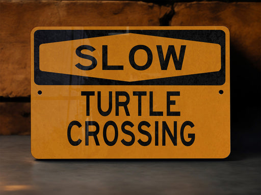 a yellow slow turtle crossing sign sitting on the ground