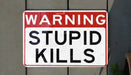 a red and white street sign hanging from the side of a building