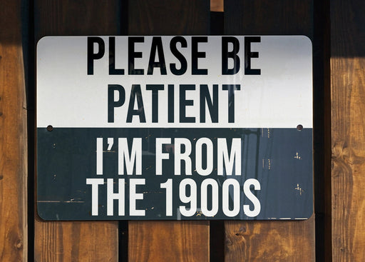 a black and white sign on a wooden fence