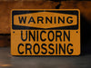 a close up of a street sign with a brick wall in the background