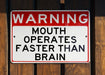 a red and white sign on a wooden fence