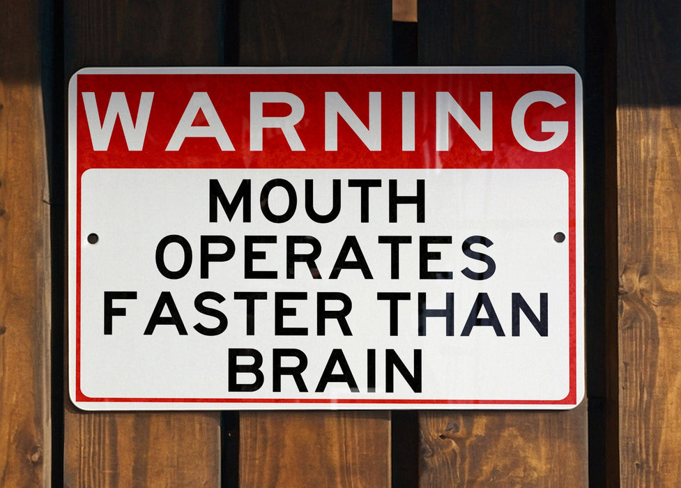 a red and white sign on a wooden fence