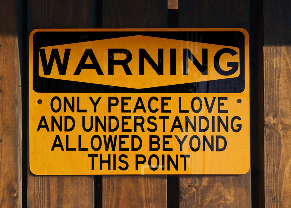 a yellow and black sign on a wooden fence