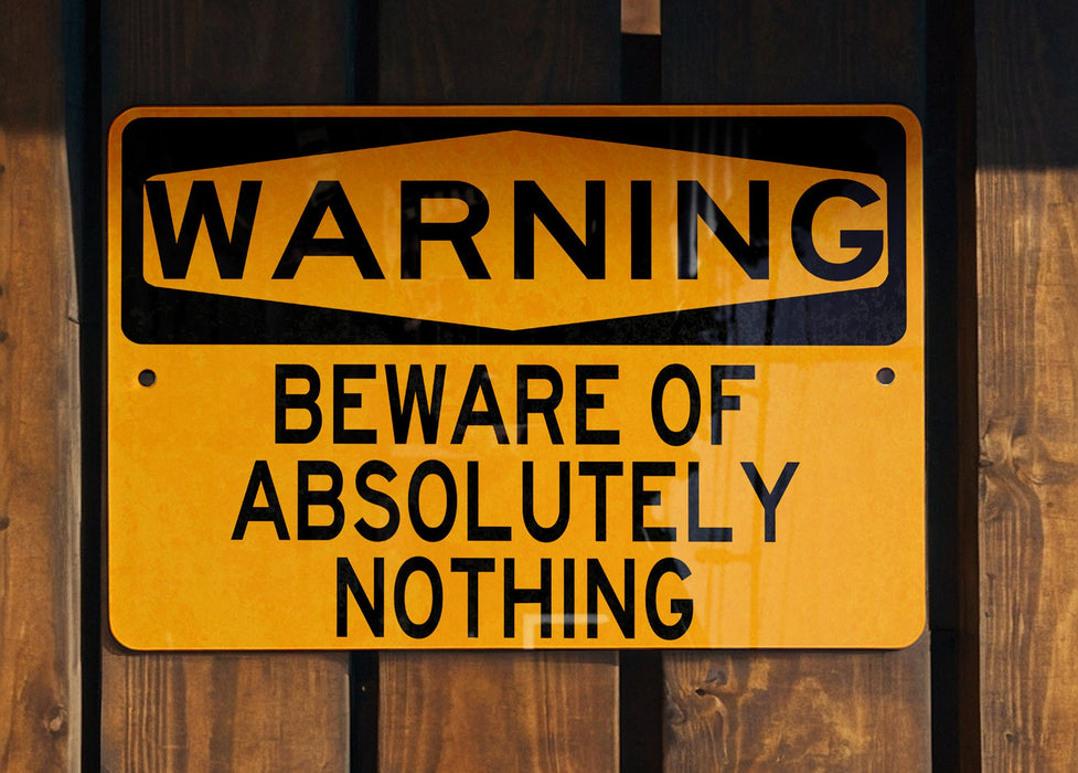 a yellow and black sign on a wooden fence