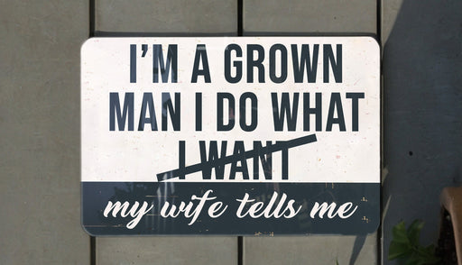 a white and black street sign on a wooden fence