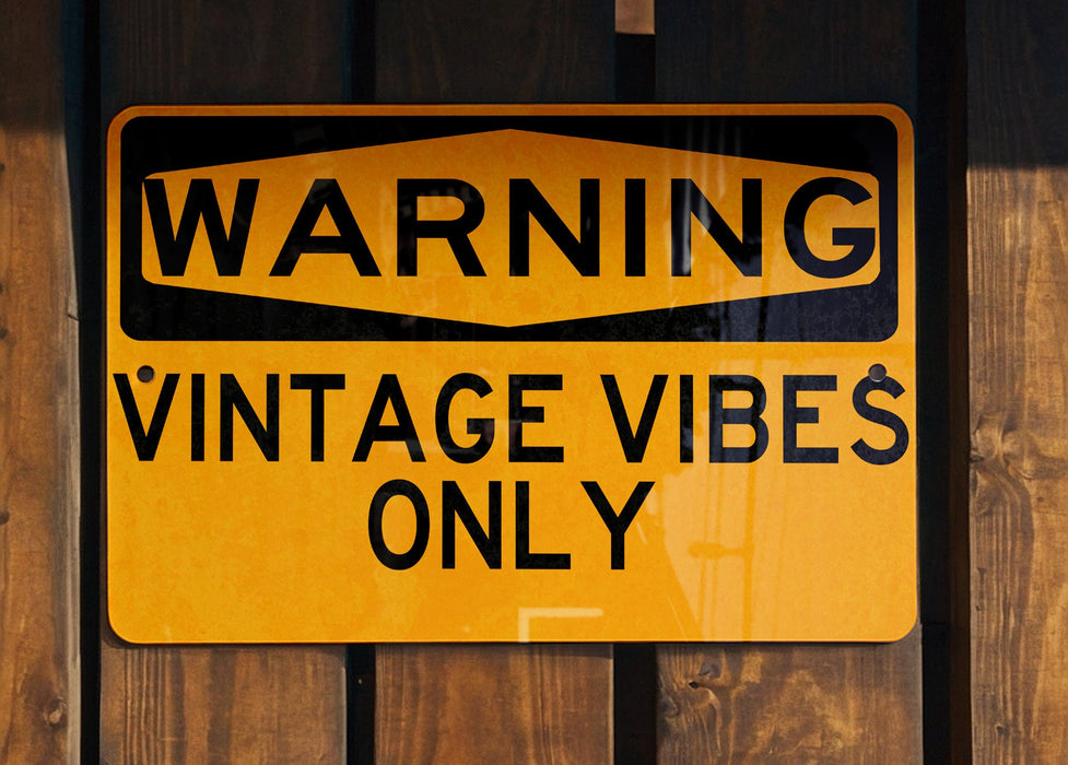 a yellow and black sign on a wooden fence