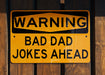 a yellow and black sign on a wooden fence